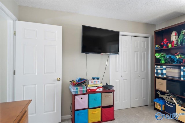 recreation room featuring carpet flooring and a textured ceiling