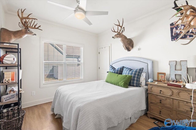 bedroom with light wood-type flooring, ceiling fan, and crown molding