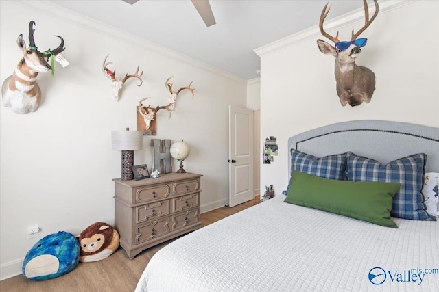 bedroom with light hardwood / wood-style floors, ceiling fan, and ornamental molding