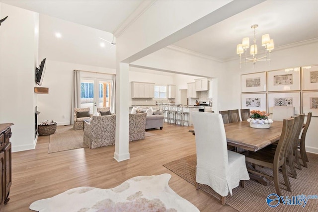 dining space featuring a chandelier, light hardwood / wood-style floors, and ornamental molding