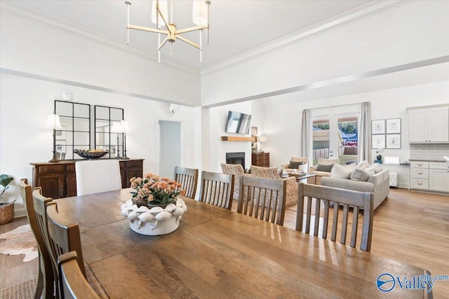 dining area featuring a chandelier, light hardwood / wood-style floors, and ornamental molding