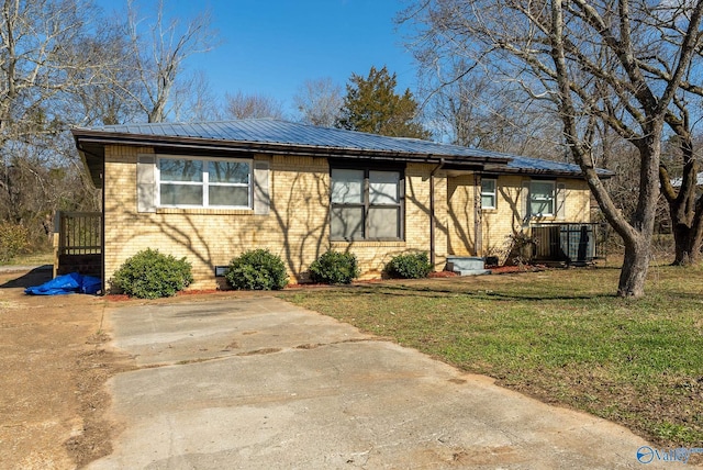 view of front of house with a front yard and central AC unit