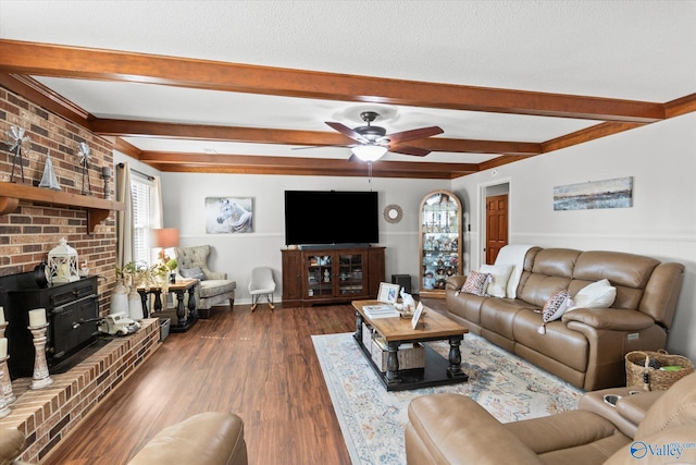 living area featuring ceiling fan, a textured ceiling, dark wood-style floors, beamed ceiling, and a wood stove