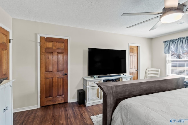 bedroom with a textured ceiling, dark wood finished floors, a ceiling fan, and baseboards