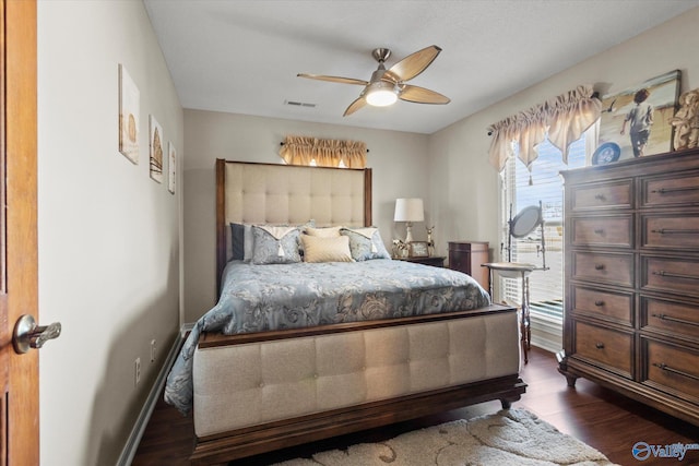 bedroom featuring dark wood-style floors, a ceiling fan, visible vents, and baseboards