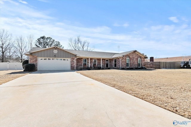 single story home featuring concrete driveway, brick siding, an attached garage, and fence