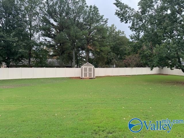 view of yard featuring a storage shed, an outdoor structure, and a fenced backyard