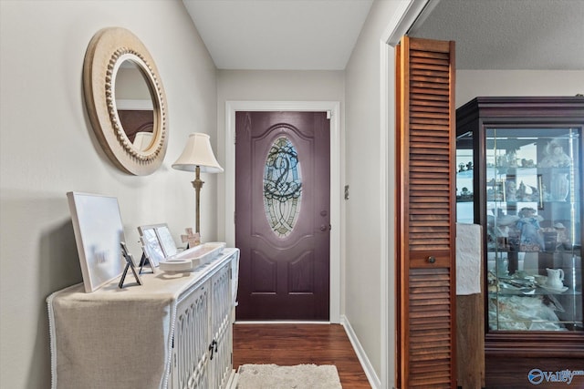 entryway featuring dark wood finished floors and baseboards