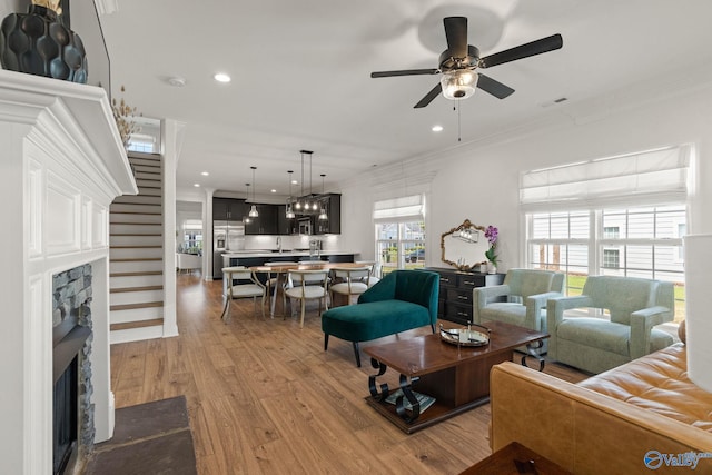 living room with ceiling fan, hardwood / wood-style flooring, and crown molding