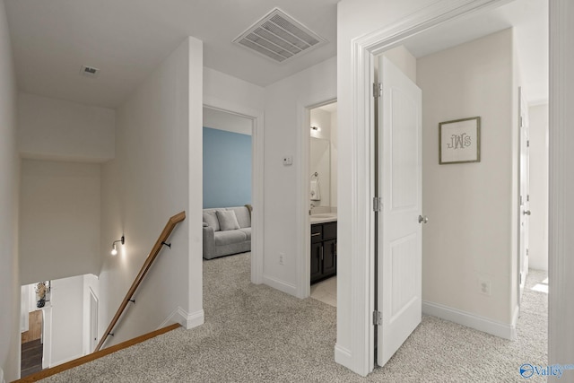 hallway featuring light colored carpet