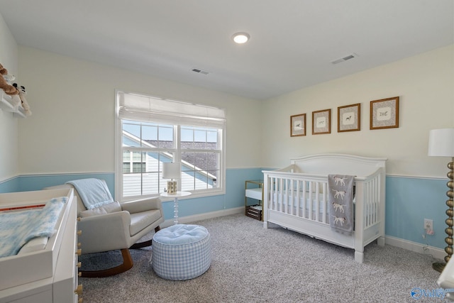 carpeted bedroom with a nursery area