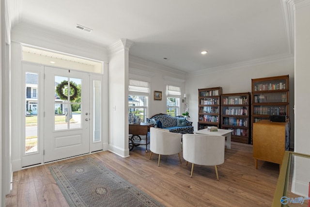 foyer featuring hardwood / wood-style floors, plenty of natural light, and crown molding