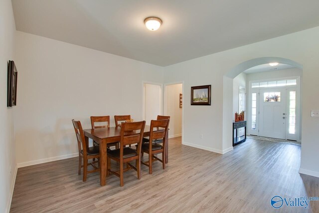 4304 Adventura Dr, Owens Cross Roads, AL 35763 - dining room featuring arched walkways, wood finished floors, and baseboards