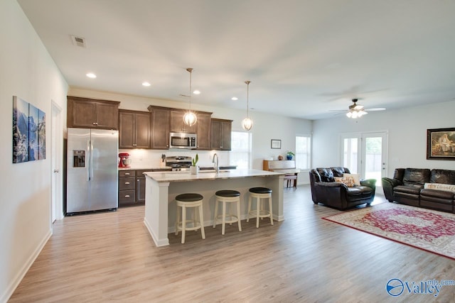 4304 Adventura Dr, Owens Cross Roads, AL 35763 - kitchen featuring appliances with stainless steel finishes, light wood finished floors, a kitchen breakfast bar, a ceiling fan, and an island with sink