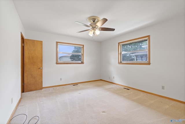 unfurnished room with baseboards, a wealth of natural light, and ceiling fan
