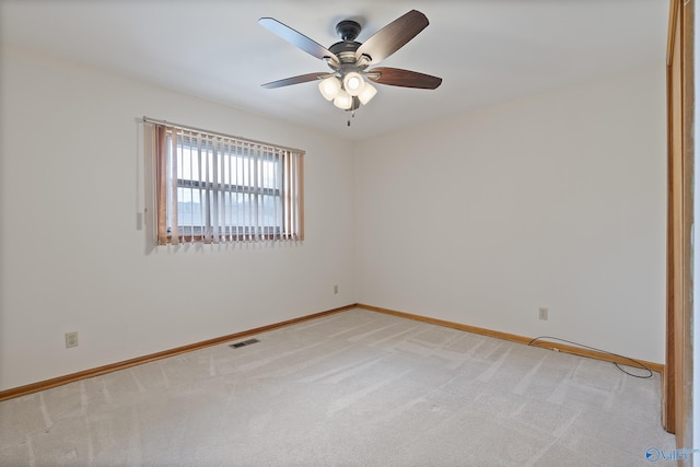 spare room featuring light carpet, baseboards, visible vents, and ceiling fan