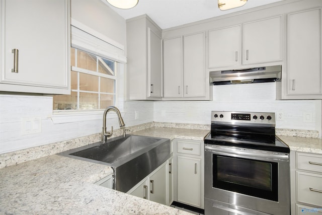 kitchen featuring stainless steel range with electric cooktop, a sink, under cabinet range hood, and decorative backsplash