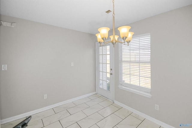 unfurnished dining area with an inviting chandelier, visible vents, and baseboards