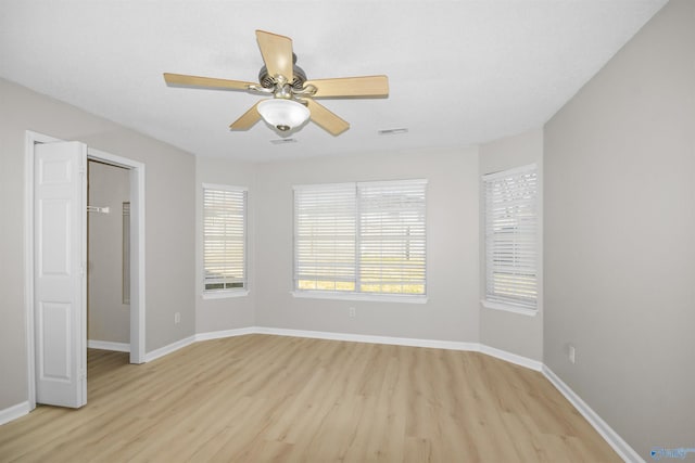 unfurnished room with a healthy amount of sunlight, baseboards, and visible vents