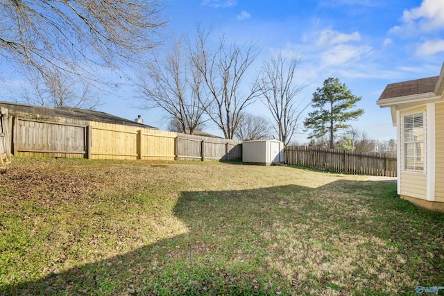 view of yard with an outbuilding, a shed, and a fenced backyard