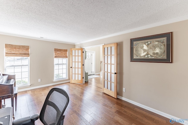 office with ornamental molding, french doors, a textured ceiling, and wood finished floors