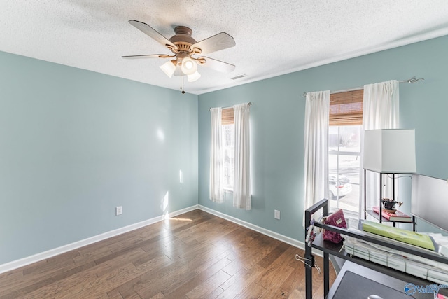 office with a healthy amount of sunlight, ceiling fan, visible vents, and dark wood finished floors