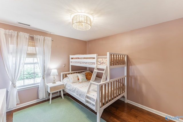 bedroom with baseboards, visible vents, a chandelier, and dark wood-style flooring