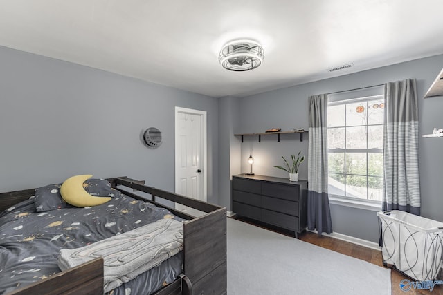 bedroom featuring dark wood-style floors, visible vents, and baseboards