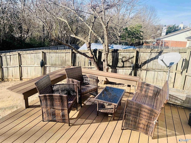 wooden deck with a fenced backyard and an outdoor living space