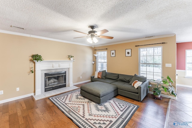 living area with a fireplace with flush hearth, visible vents, ceiling fan, and hardwood / wood-style floors