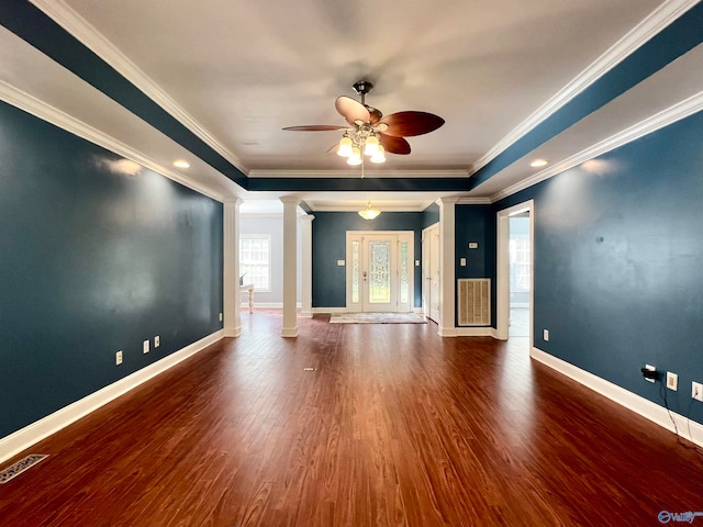 unfurnished room with ornate columns, wood-type flooring, ceiling fan, crown molding, and a tray ceiling