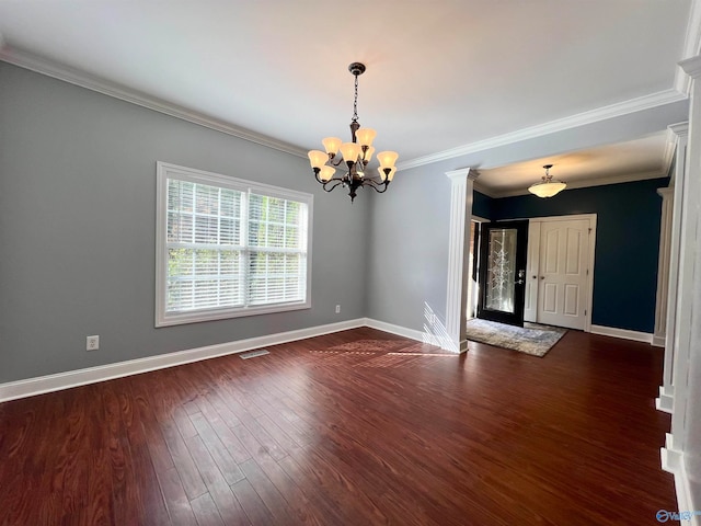 unfurnished room with decorative columns, a chandelier, dark hardwood / wood-style floors, and crown molding