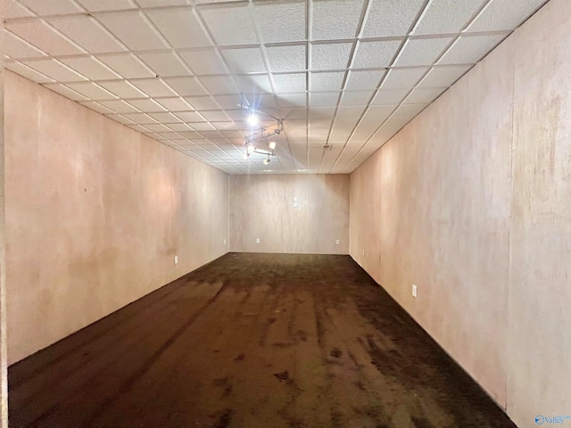 basement with a drop ceiling and carpet flooring