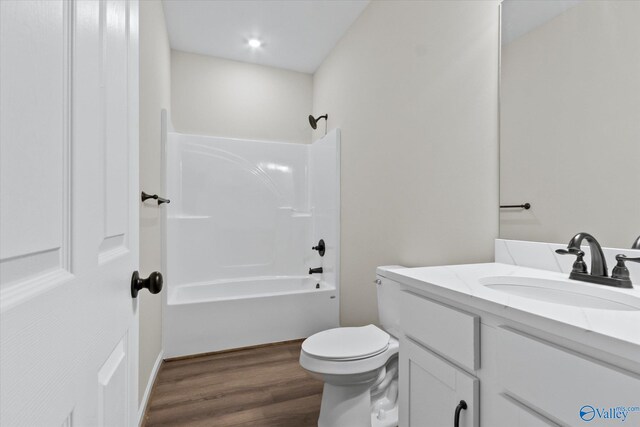 full bathroom featuring hardwood / wood-style floors, toilet, bathtub / shower combination, and vanity