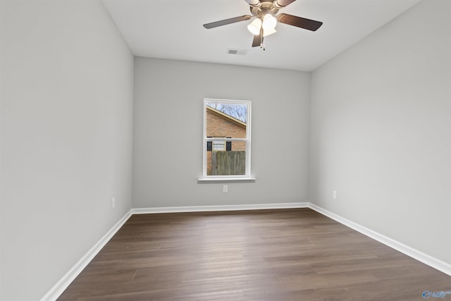 empty room featuring dark wood-type flooring and ceiling fan