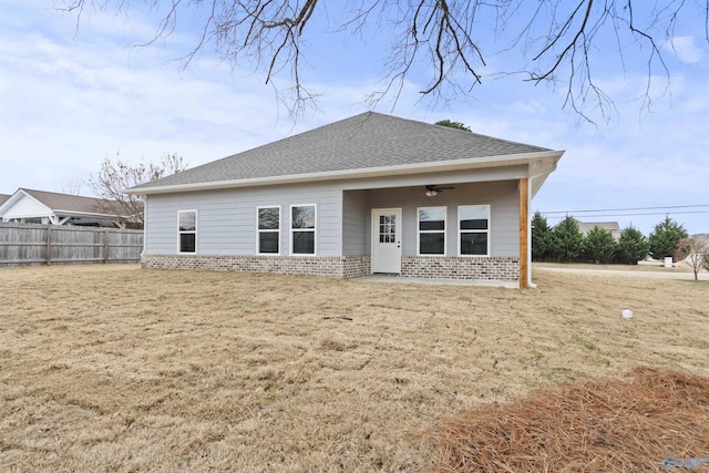 rear view of property with a yard and ceiling fan