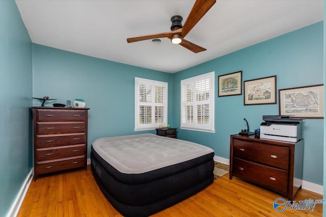 bedroom with ceiling fan, baseboards, and wood finished floors