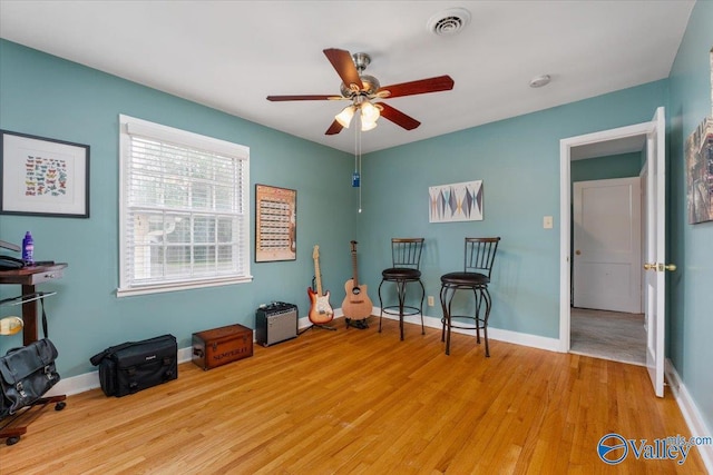 interior space with light wood finished floors, visible vents, a ceiling fan, and baseboards