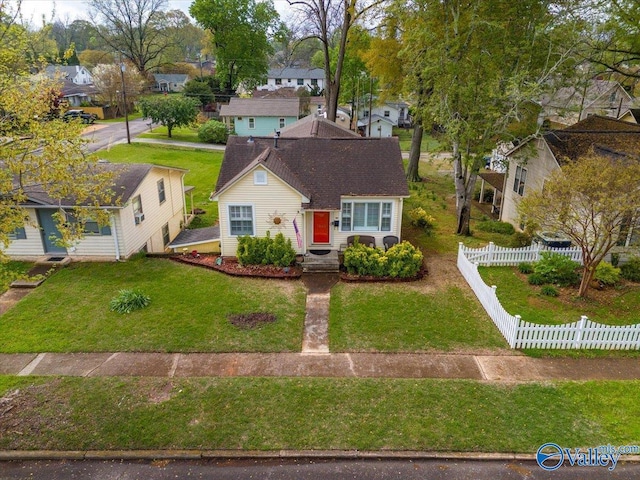 view of front of property with a residential view, a front yard, and fence