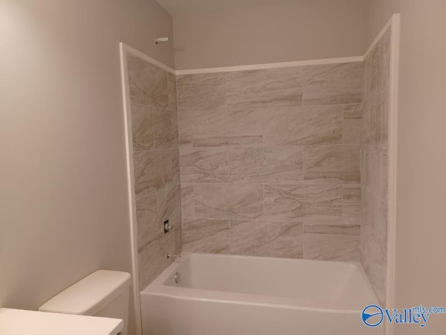 bathroom with tiled shower / bath and toilet