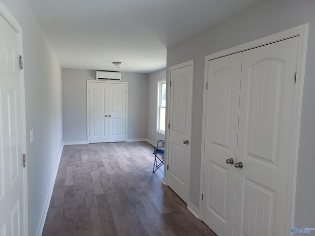 hall featuring dark wood-type flooring and a wall mounted AC