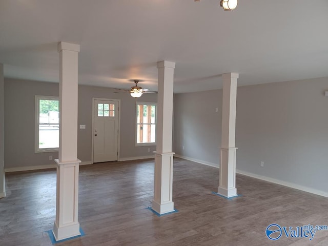 entryway with ornate columns, wood-type flooring, and a healthy amount of sunlight