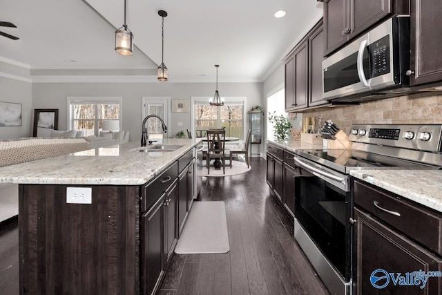 kitchen with sink, pendant lighting, a kitchen island with sink, dark brown cabinets, and appliances with stainless steel finishes