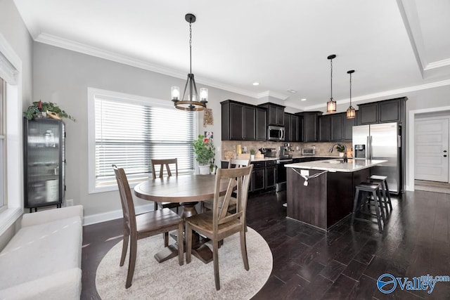 dining space featuring a chandelier, dark hardwood / wood-style flooring, crown molding, and sink