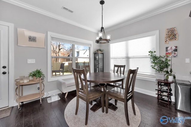 dining room with ornamental molding, an inviting chandelier, and dark wood-type flooring