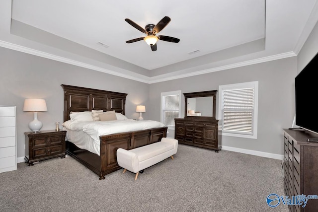 carpeted bedroom with a tray ceiling, ceiling fan, and ornamental molding