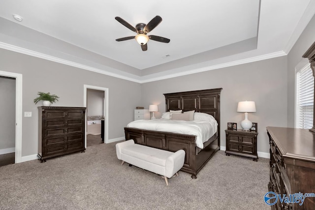 carpeted bedroom with ceiling fan, connected bathroom, and a tray ceiling