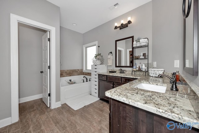 bathroom with a washtub and vanity