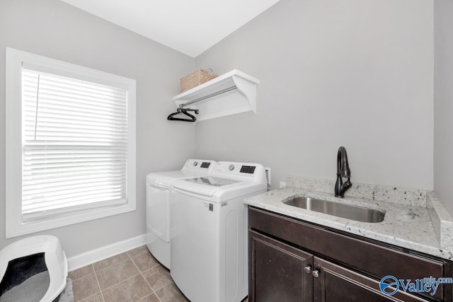 laundry area featuring washing machine and clothes dryer, light tile patterned floors, cabinets, and sink