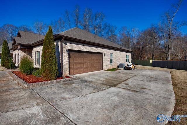 view of side of property with central air condition unit and a garage